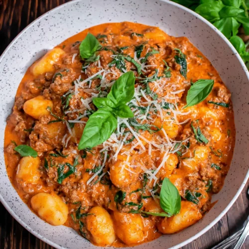 Creamy Sausage Gnocchi: A Flavorful Weeknight Delight 1 Creamy sausage gnocchi topped with basil and parmesan.