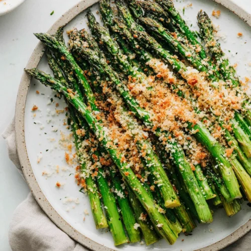 Roasted Asparagus: A Delicious and Easy Side Dish 1 Delicious roasted asparagus topped with cheese and breadcrumbs.