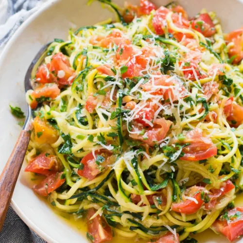 Zucchini Noodles: A Quick and Savory Low-Carb Delight 1 Healthy zucchini noodles with tomatoes and parmesan.