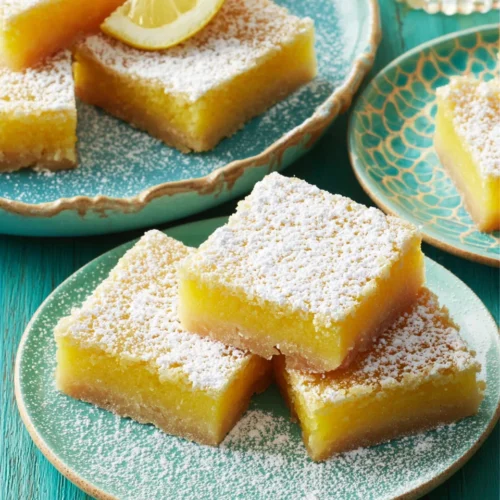 Lemon Bars: Delightfully Tangy and Refreshingly Simple 1 Delicious lemon bars dusted with powdered sugar on plates.