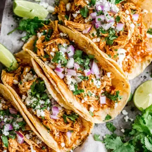 Delicious Chicken Tinga Tacos for Quick Weeknight Dinners 1 Flavorful chicken tinga tacos topped with onions and lime.