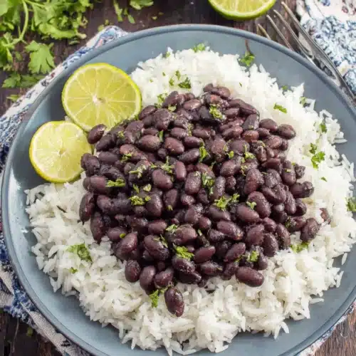 Cuban Style Black Beans: A Flavorful and Easy Delight 1 Savory Cuban style black beans over rice, garnished with parsley.