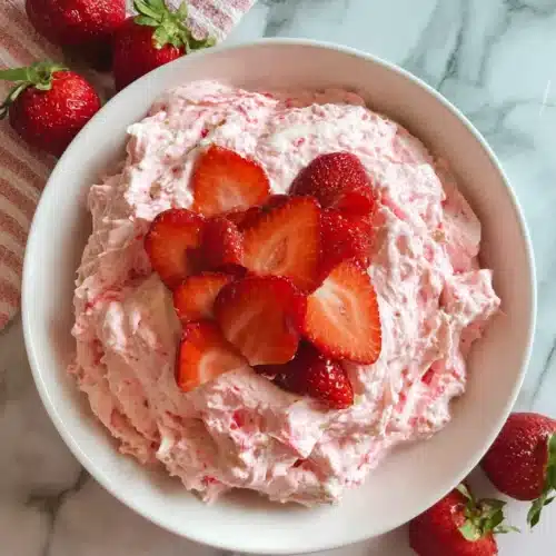 Delicious Strawberry Fluff Salad Recipe You’ll Love 1 Creamy strawberry fluff salad in a white bowl with fresh strawberries