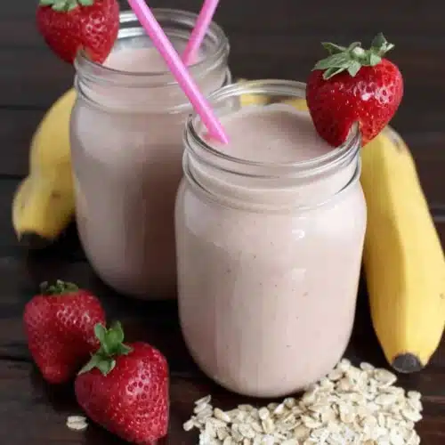 Creamy Strawberry Banana Smoothie Delight: A Refreshing Treat 1 Creamy strawberry banana smoothie delight in glass jars with fresh strawberries and bananas