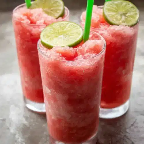 Healthy Watermelon Slushie: A Refreshing Summer Treat 1 Three glasses of healthy watermelon slushie with lime garnish and green straws