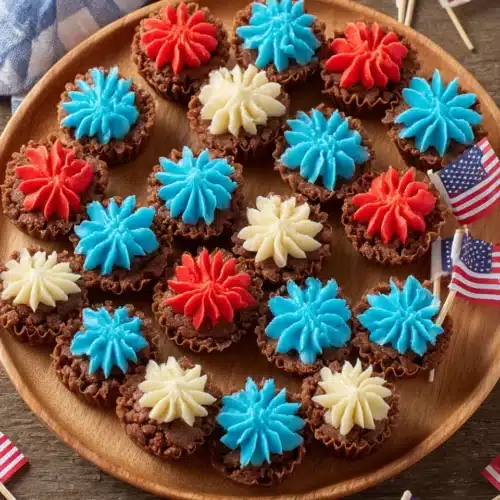 Mini Brownie Bites: Irresistibly Delicious and Easy! 1 Mini brownie bites with red, white, and blue frosting on a wooden board with American flags