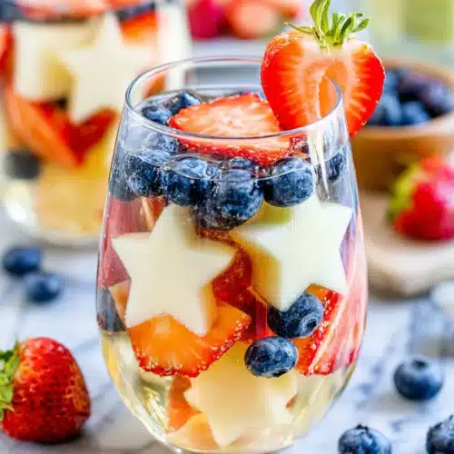 Patriotic Sangria: Refreshing and Festive Delight 1 Patriotic sangria with strawberries, blueberries, and star-shaped melon in a glass