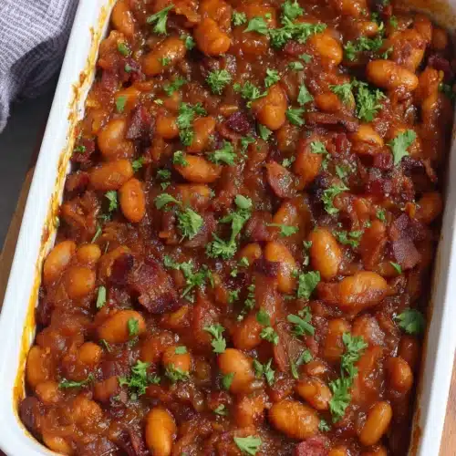 Paula Deen Baked Beans: A Comforting Delight 1 Paula Deen baked beans in a white dish, garnished with parsley