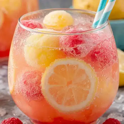 Sherbet Punch: A Refreshingly Fun Treat for Everyone! 1 Colorful sherbet punch with rainbow sherbet scoops and fresh fruit in a glass bowl