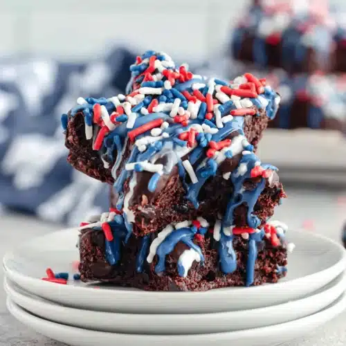 Star Spangled Brownies: A Delicious Celebration 1 Star spangled brownies with blue drizzle and red, white, blue sprinkles on white plates