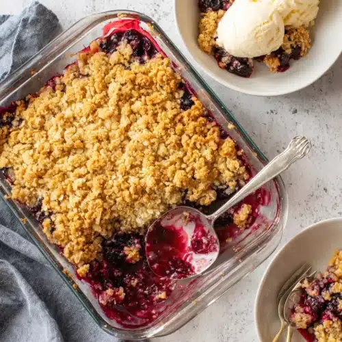 Triple berry crisp with golden oat topping and juicy berries, served with vanilla ice cream