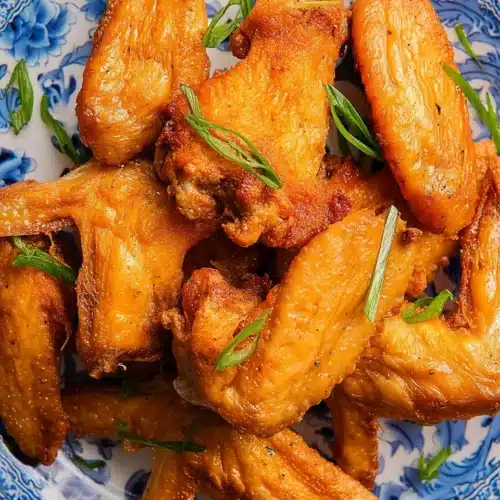 Fried Chicken Wings (Chinese Restaurant Style) - Irresistibly Crisp! 1 Crispy fried chicken wings (Chinese restaurant style) on a blue and white plate with green onions