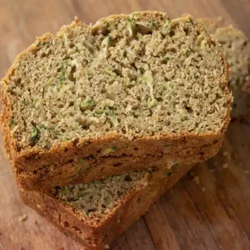 Delicious Gluten-Free Zucchini Bread Recipe to Savor 2 Moist gluten-free zucchini bread slices on wooden board