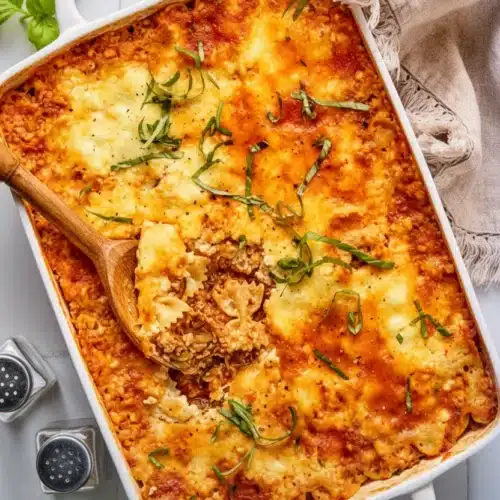 Delicious Italian Zucchini and Ground Beef Casserole 2 Italian zucchini and ground beef casserole in a white baking dish with melted cheese and basil