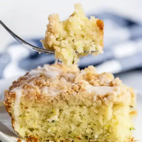 Lemon Zucchini Coffee Cake: A Delightfully Sweet Treat 2 Moist lemon zucchini coffee cake with crumb topping and glaze on a white plate