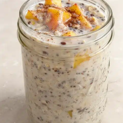 Overnight Peach Cobbler Oatmeal: A Delightful Make-Ahead Breakfast 2 Overnight peach cobbler oatmeal in a jar with peaches and cinnamon