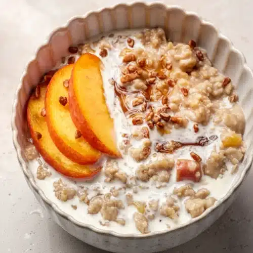Peaches and Cream Oatmeal: A Creamy Morning Delight 2 Peaches and cream oatmeal in a bowl with fresh peach slices and nuts