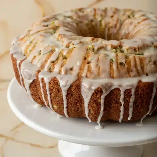 Pineapple Zucchini Bundt Cake: A Delightful Dessert 2 Pineapple zucchini bundt cake with white glaze on a white plate