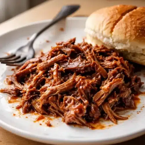 Pioneer Woman Pulled Pork Recipe: Indulgent and Simple 1 Pioneer Woman pulled pork recipe served on a plate with a bun
