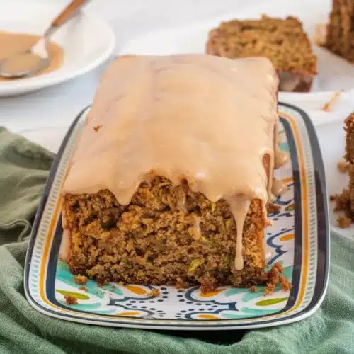 Simple Gluten-Free Zucchini Bread: A Delightful Treat 2 Moist gluten-free zucchini bread with cinnamon cream cheese glaze on a patterned plate
