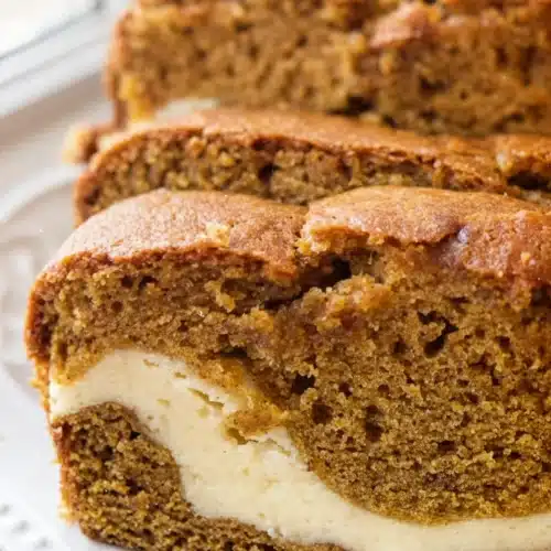 Cheesecake Stuffed Pumpkin Bread: A Delightful Treat 1 Slices of cheesecake stuffed pumpkin bread on a white plate